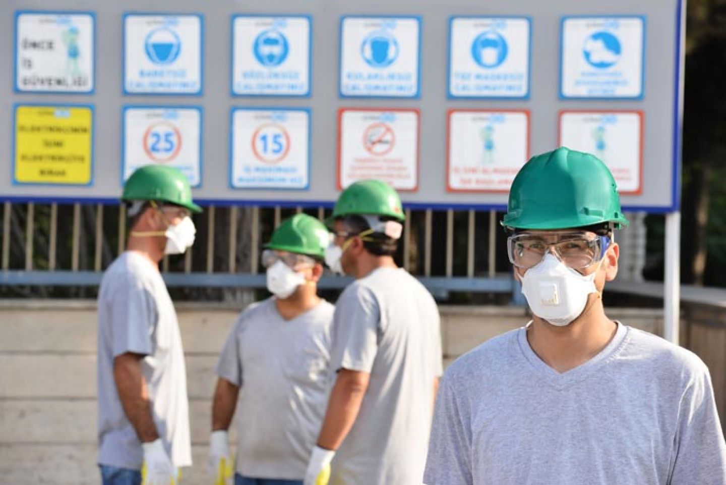 Pratende mannen met stofmasker, veiligheidsbril en helm op de bouwplaats