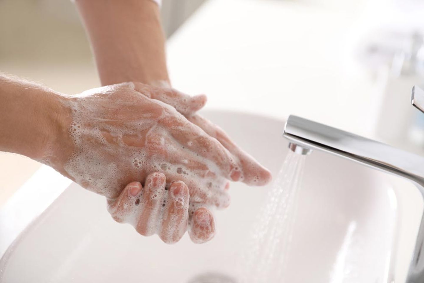 Handen wassen met zeep bij gootsteen