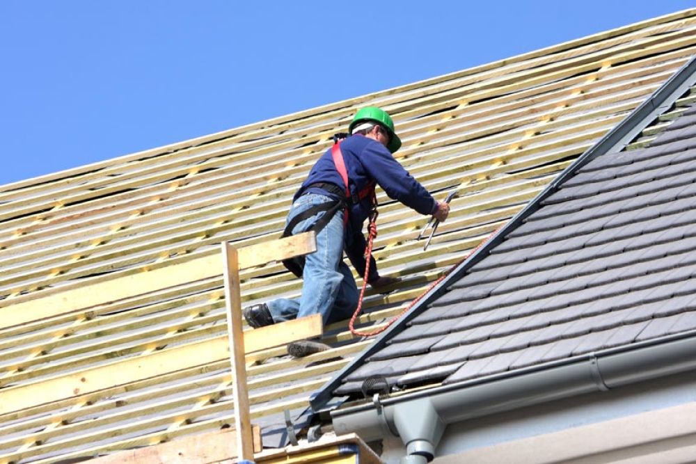 Man draagt persoonlijke beschermingsmiddelen tijdens dakwerkzaamheden