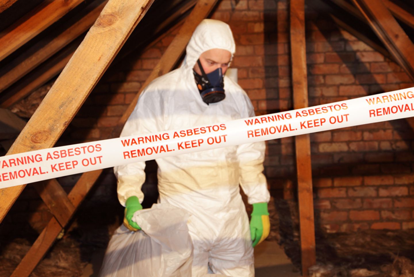 Man draagt persoonlijke beschermingsmiddelen tijdens het verwijderen van asbest
