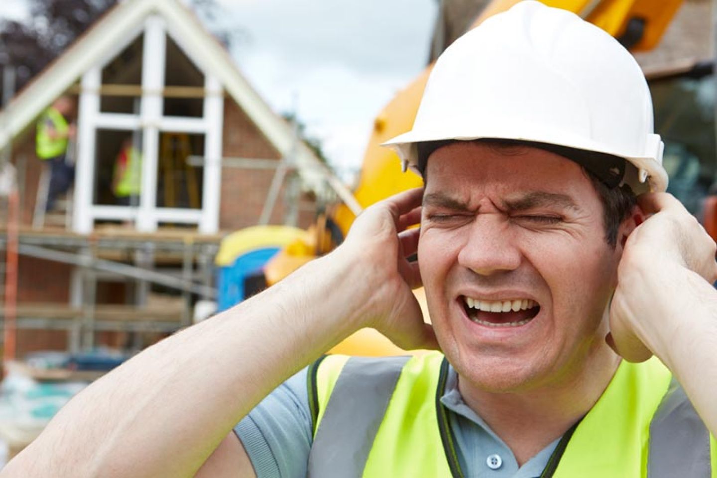 Man houdt handen bij de oren in verband met lawaai op de werkvloer